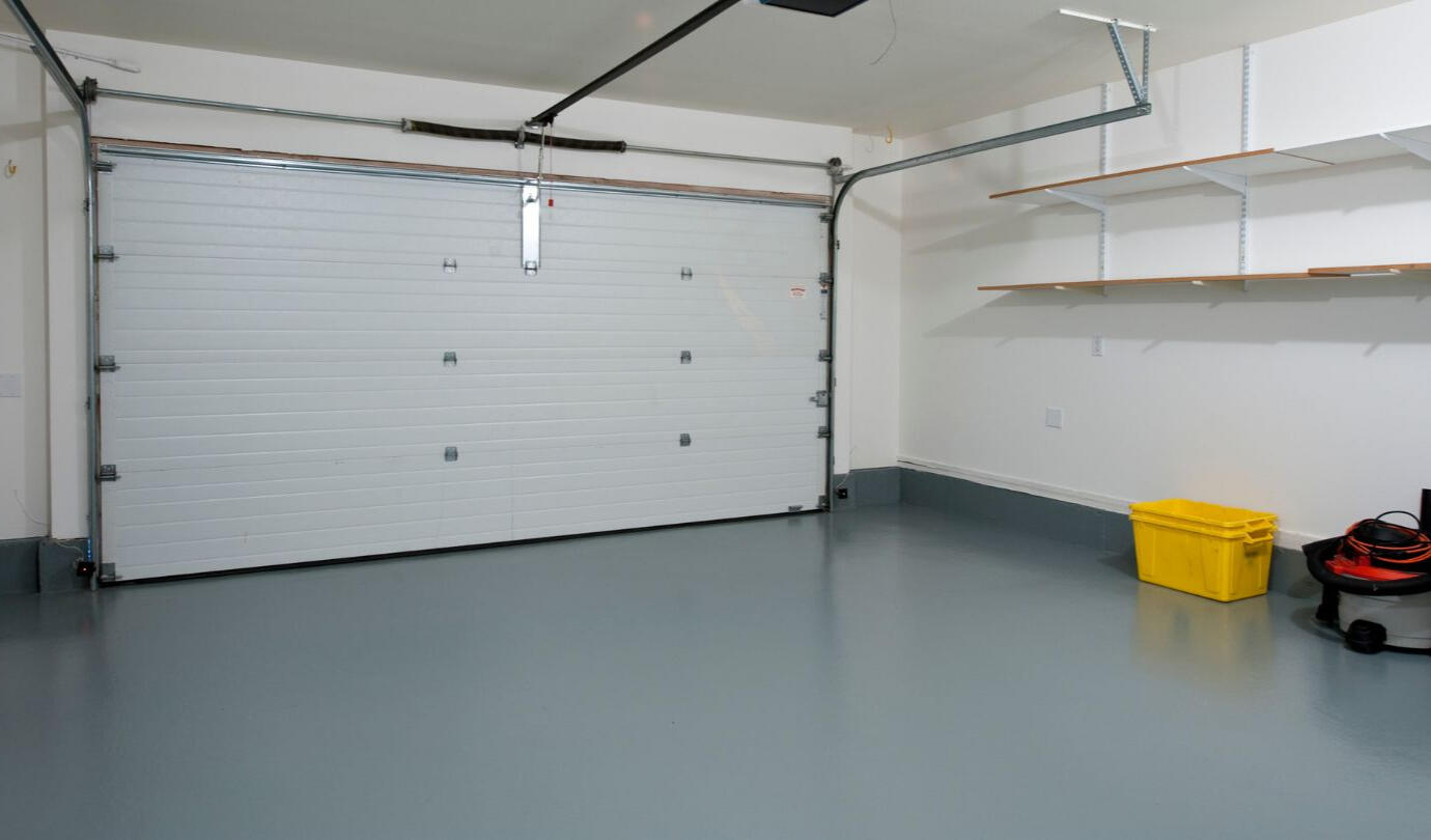 Garage Tex Garage Surface Coating Clean, crisp image of a newly completed 2 car garage with a fresh epoxy garage floor coating in a gray color showing experienced workmanship.